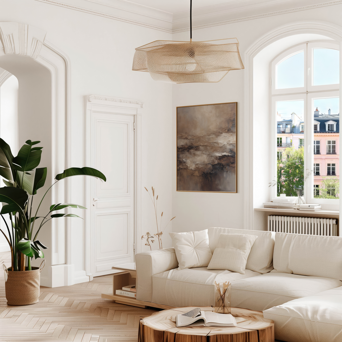 Moody abstract wall art in beige and brown tones framed above a cream sofa in a bright living room with natural light
