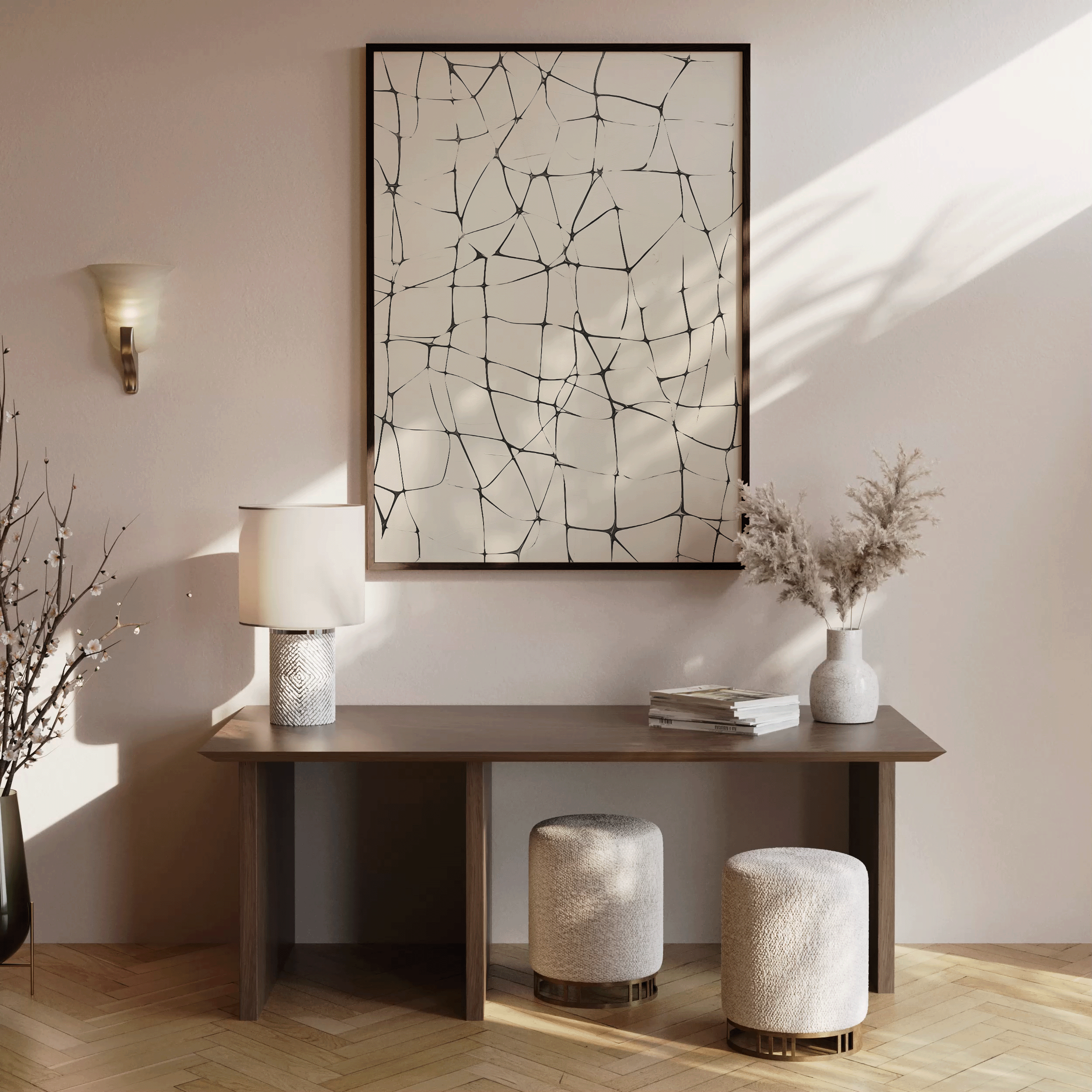 Abstract line grid wall art print in black on beige displayed above a modern wooden console table with ceramic lamp, stacked books, pampas in vase, and two textured ottomans