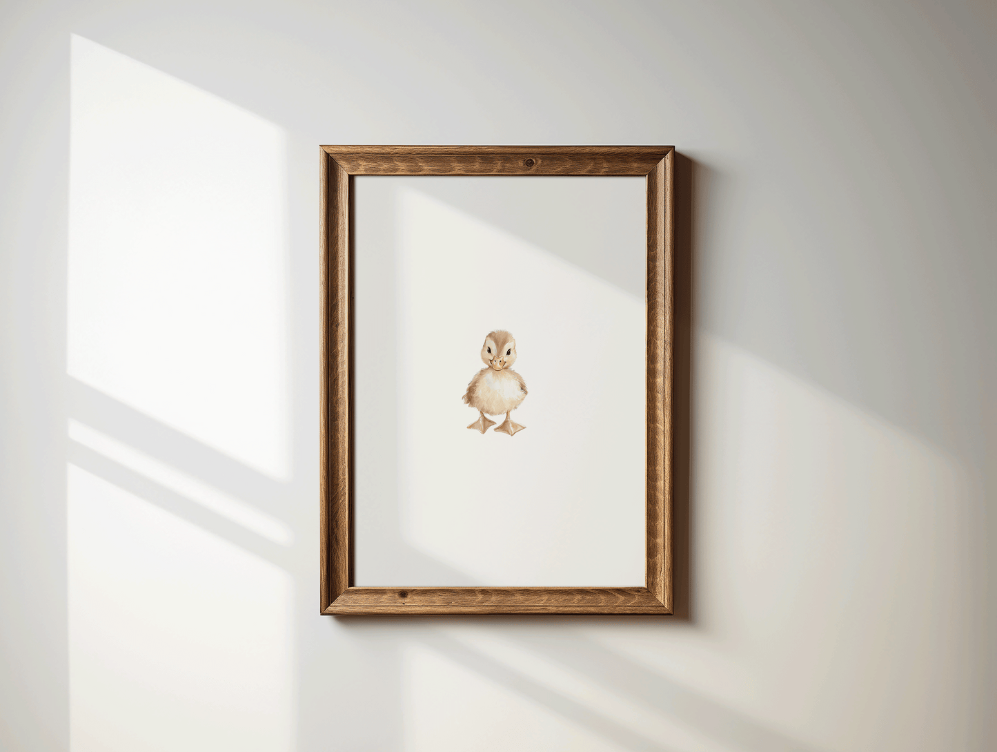 Framed woodland nursery wall art of a baby duckling in brown wood frame displayed on a white wall