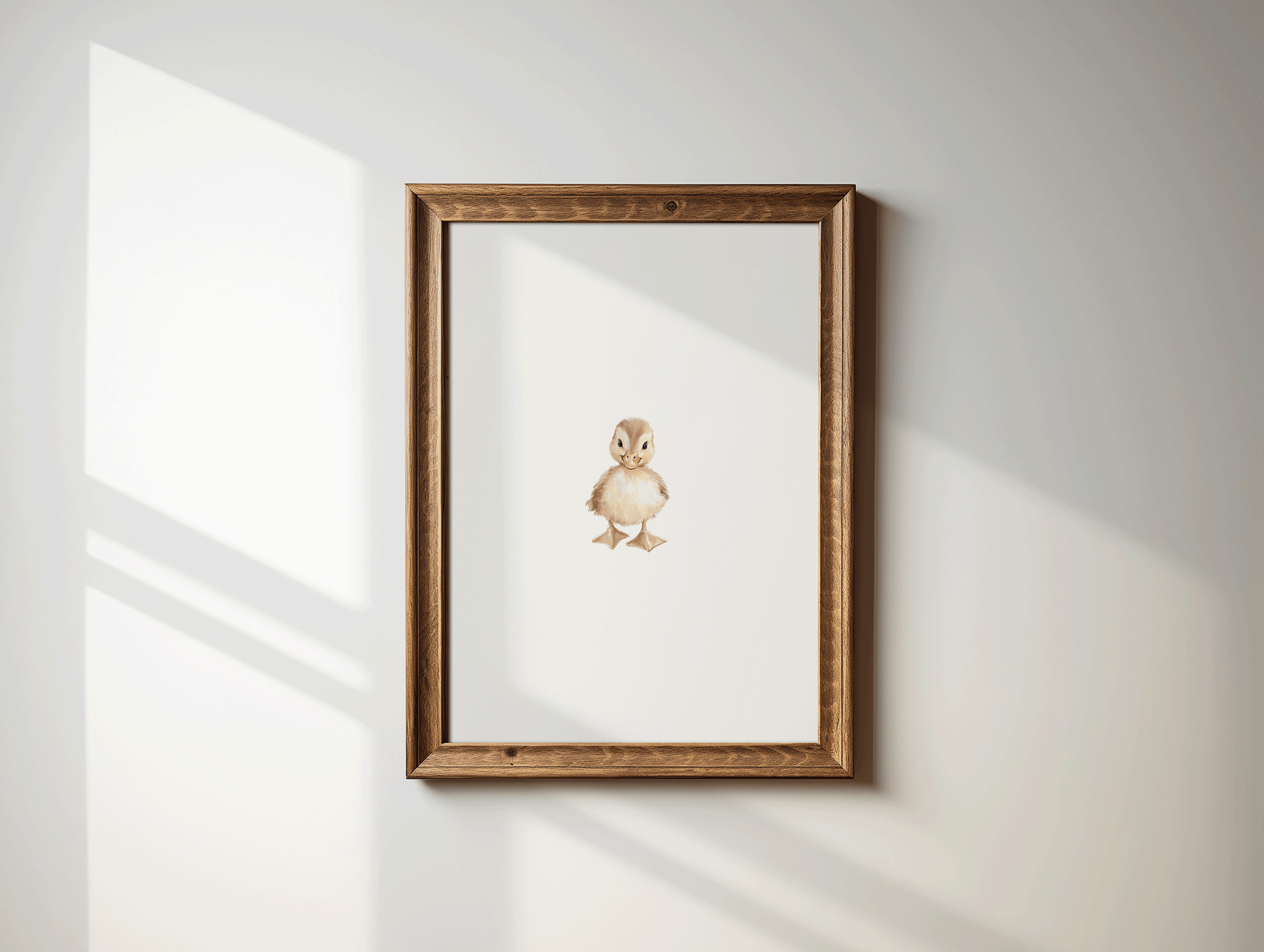 Framed woodland nursery wall art of a baby duckling in brown wood frame displayed on a white wall