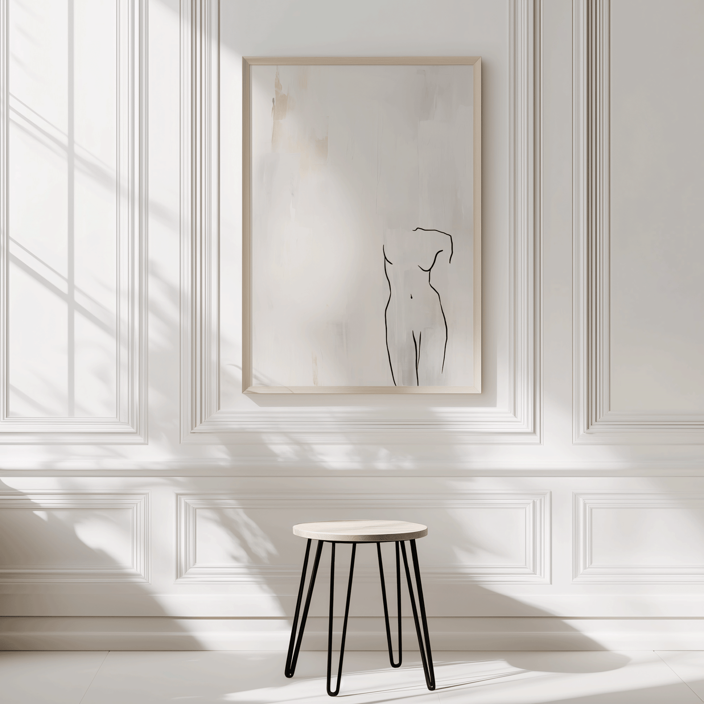 Beige frame line art wall decor with minimalist female form drawing displayed on white panel walls with soft shadows and minimalist stool underneath