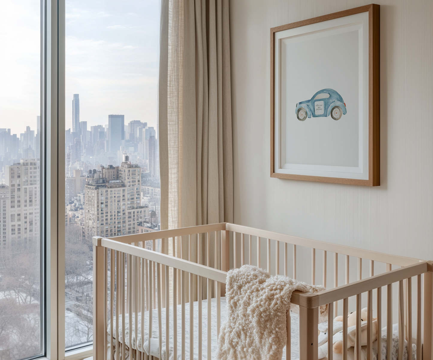 Framed blue car nursery wall art print with the words ‘Little racer big dreams,’ styled above a wooden crib in a boys’ nursery with large window and city skyline view. Perfect wall decor for baby boys’ rooms and playrooms.