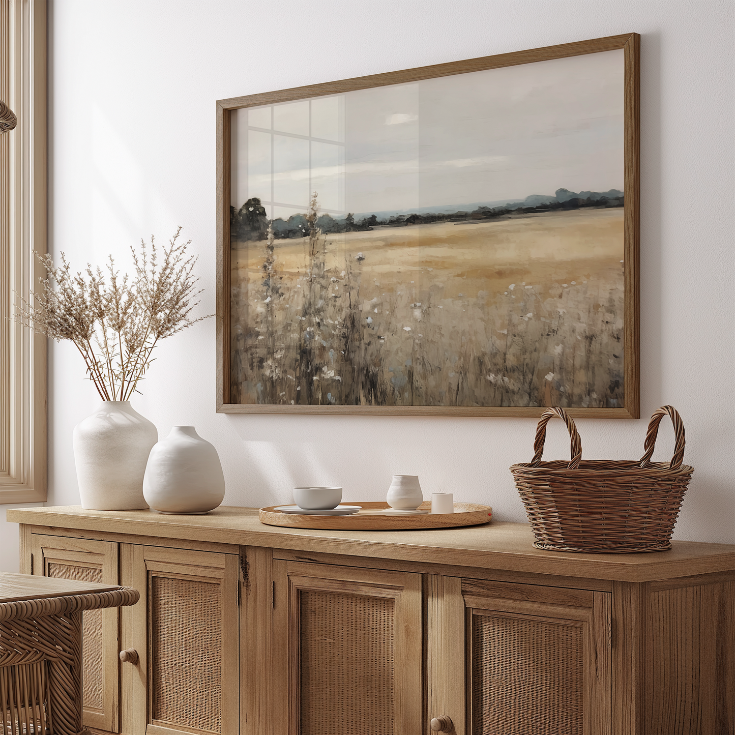 Neutral countryside landscape wall art framed in wood, hanging above a dining room sideboard. Vintage field painting print for farmhouse dining spaces.