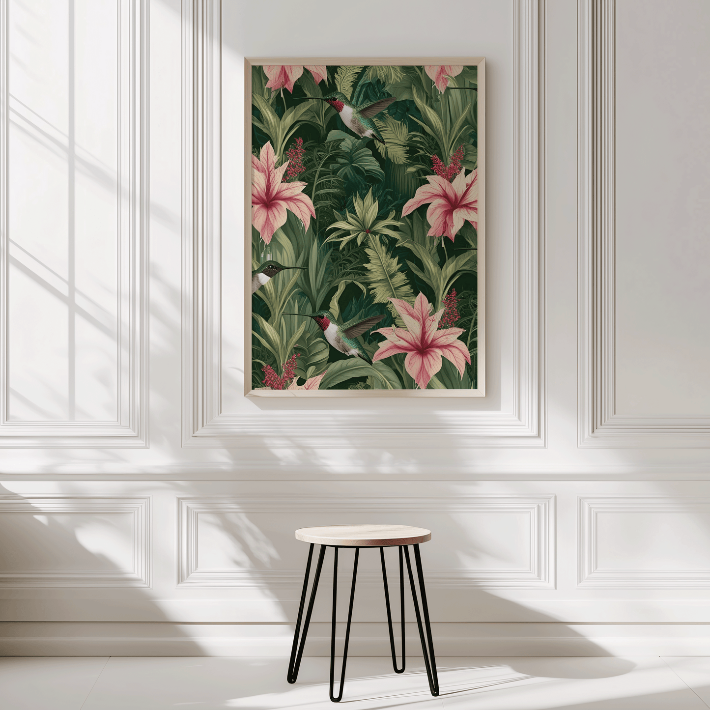 Framed hummingbird botanical wall art with lush tropical greenery and pink florals styled in a bright white interior.