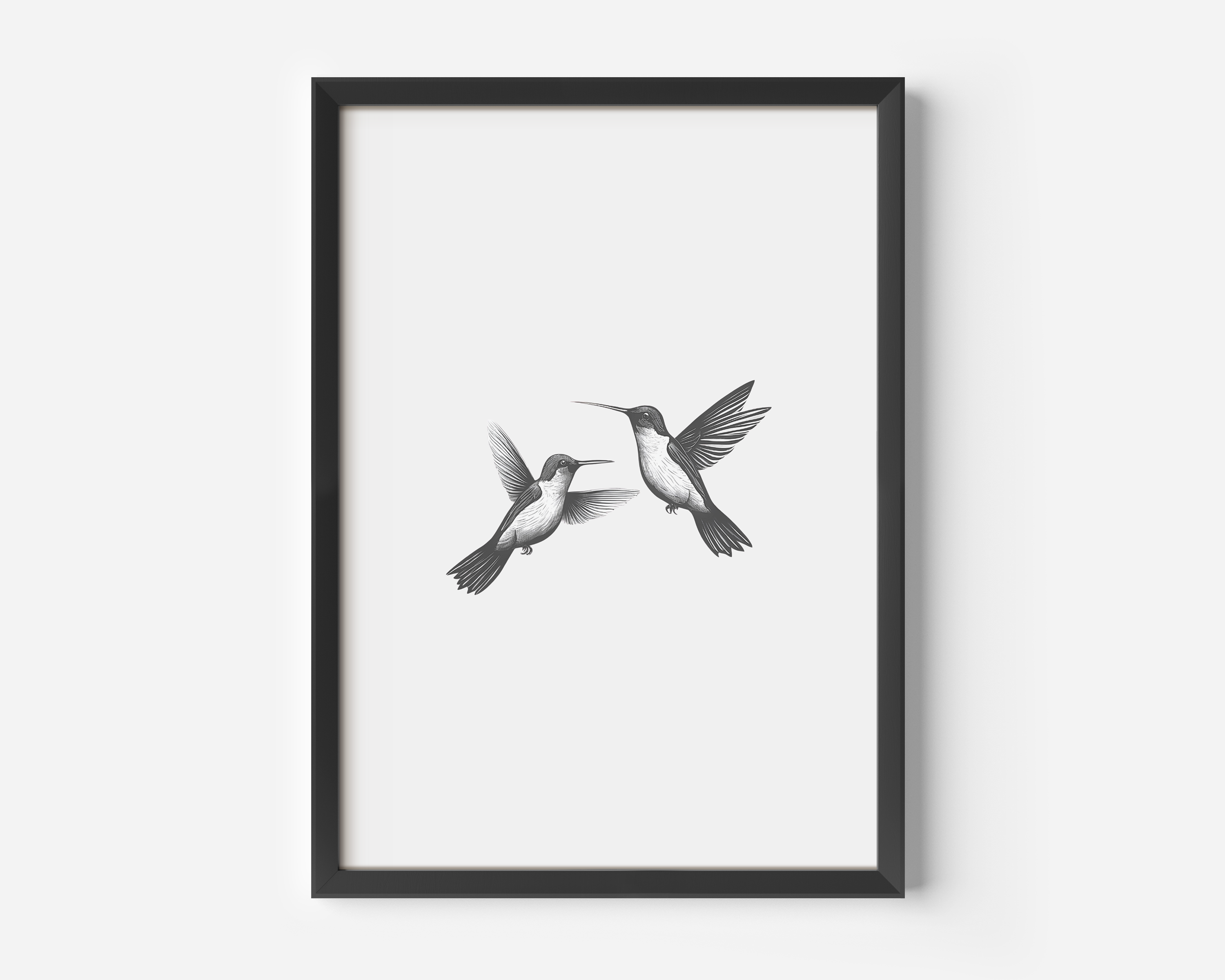 Minimalist hummingbird wall art in black and white framed in black displayed on a clean white wall