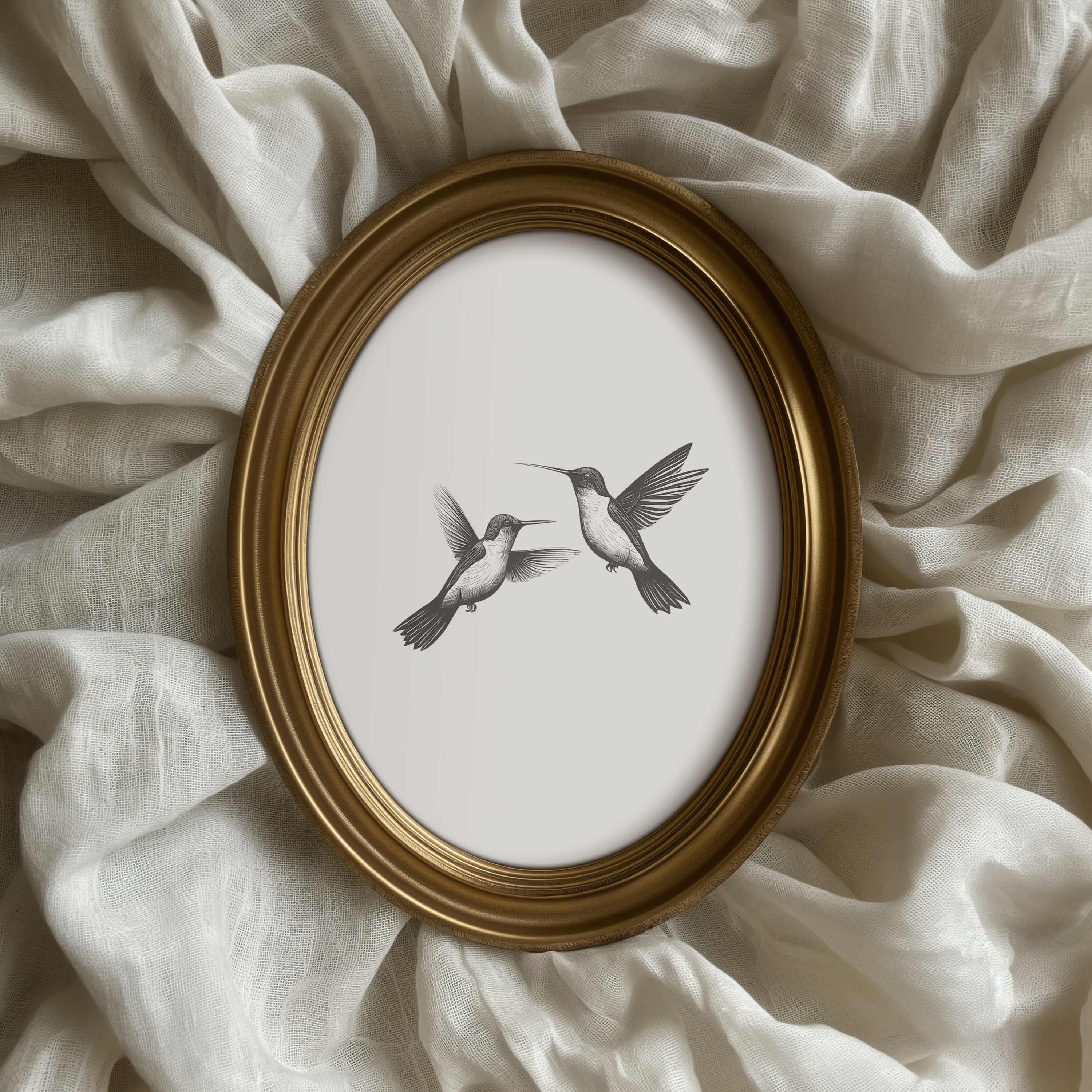 Minimalist hummingbird wall art in black and white oval framed print styled on soft neutral fabric
