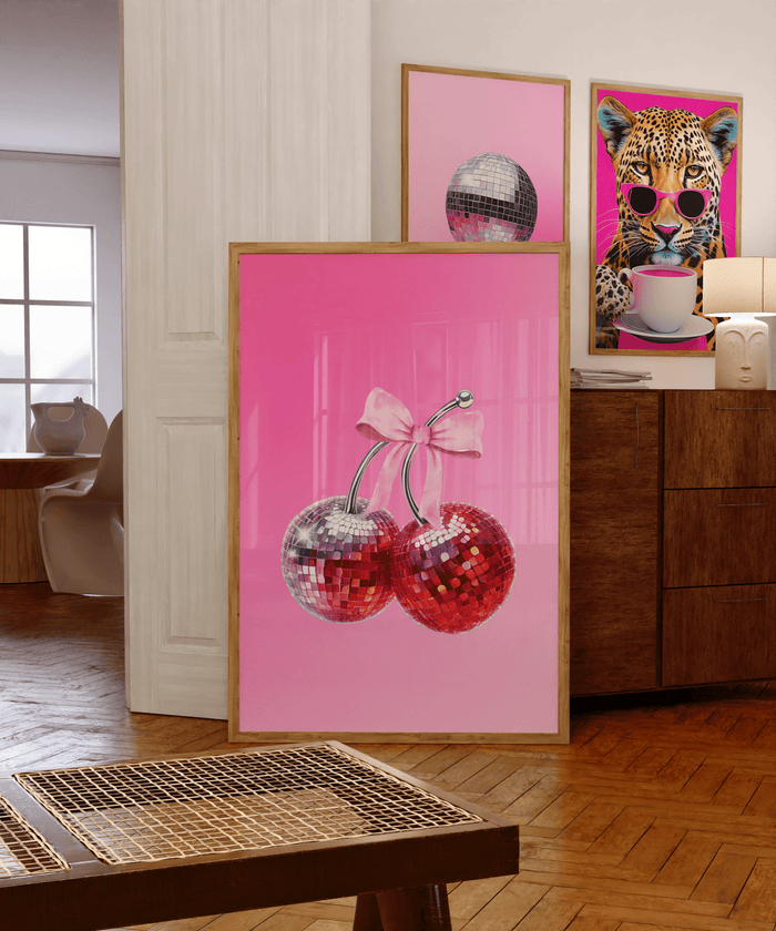 Funky gallery wall of a cherry disco ball print, a disco ball print and a leopard print on a wooden sideboard