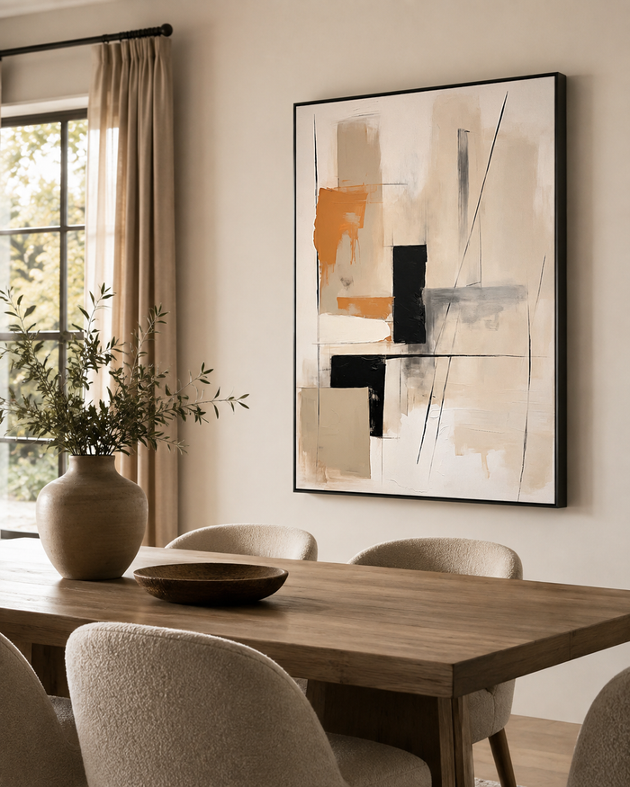 Warm neutral abstract canvas in a black float frame displayed above a dining table in a modern dining room