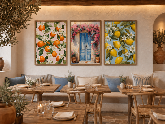 Three Mediterranean prints of oranges, a blue Greek door with bougainvillea, and lemons in brown frames displayed as a triptych in a Greek taverna