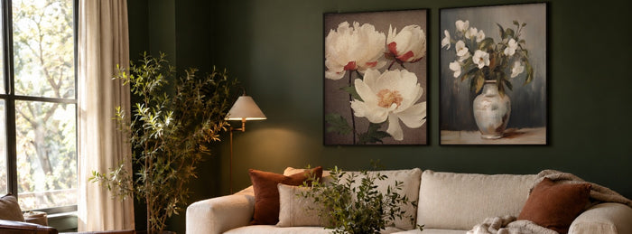 Vintage botanical and floral wall art prints in black frames above a cream sofa in a forest green living room