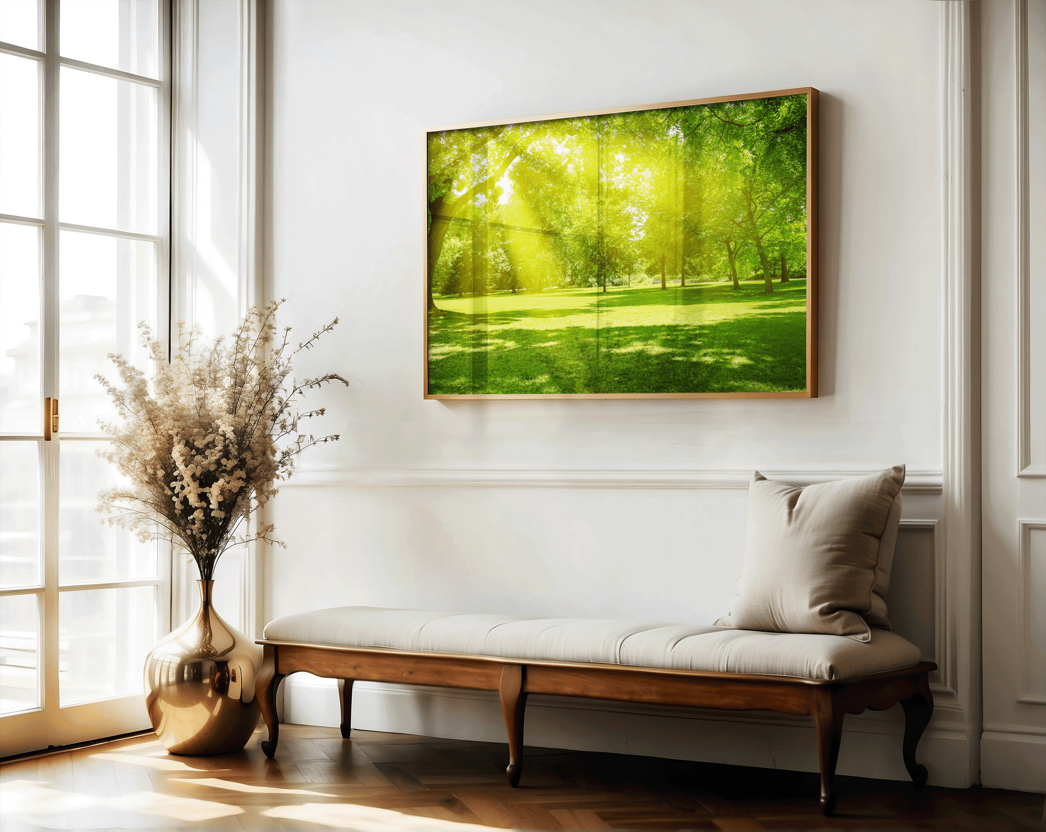 Large nature landscape art with sun rays over grassy park, styled above linen bench in classic entryway with gold vase and floral accents, inviting biophilic home decor