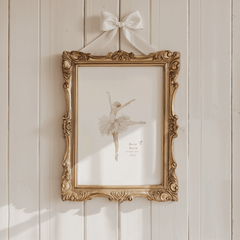 antique style beige Ballerina print in an ornate gold frame with ribbon bow; vintage girl nursery wall art in soft neutrals.