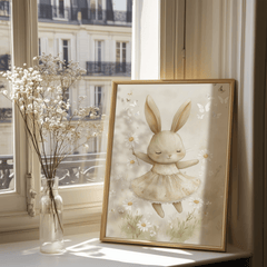 Ballerina bunny print in a gold wood frame on a windowsill beside baby's breath and a city balcony view