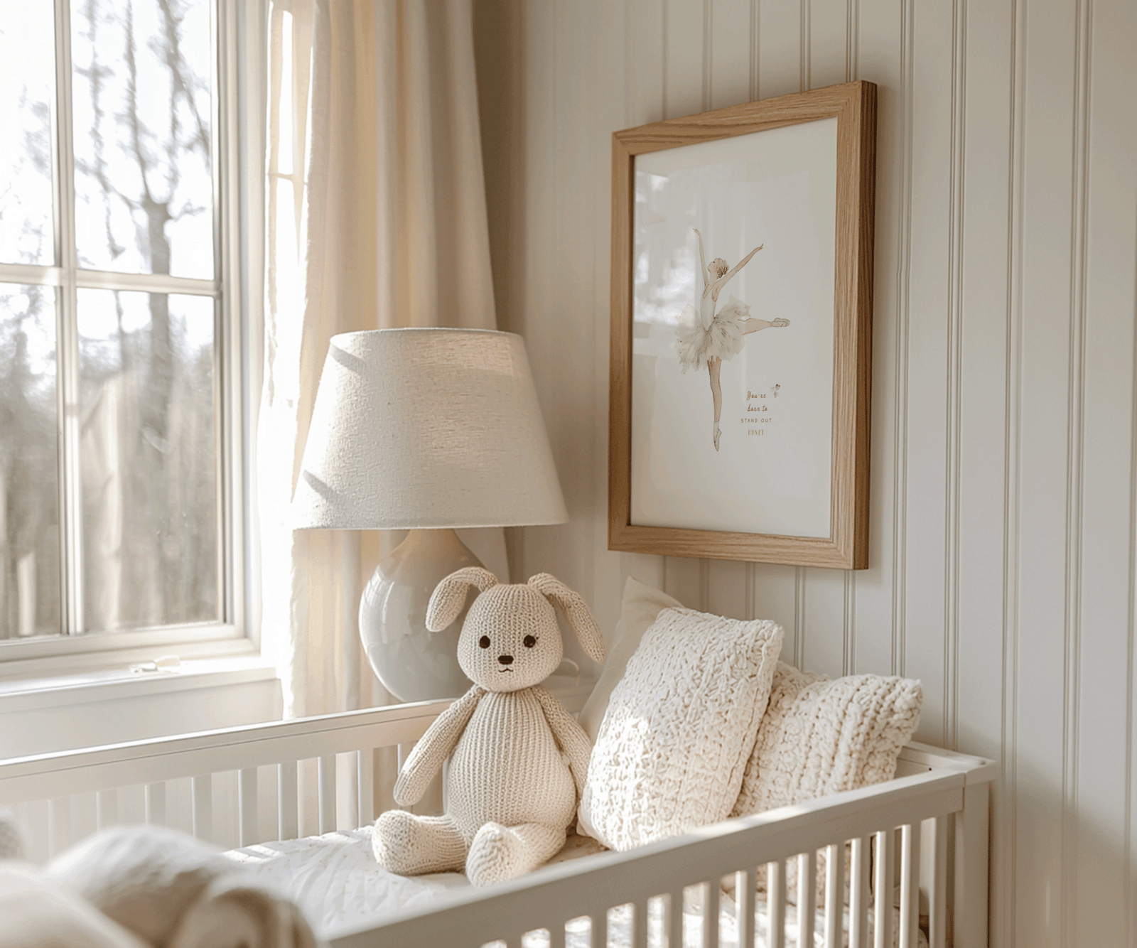 Framed vintage ballerina with tutu illustration on bead board wall; warm cream nursery styling with a plush bunny rabbit in the crib and pillows.