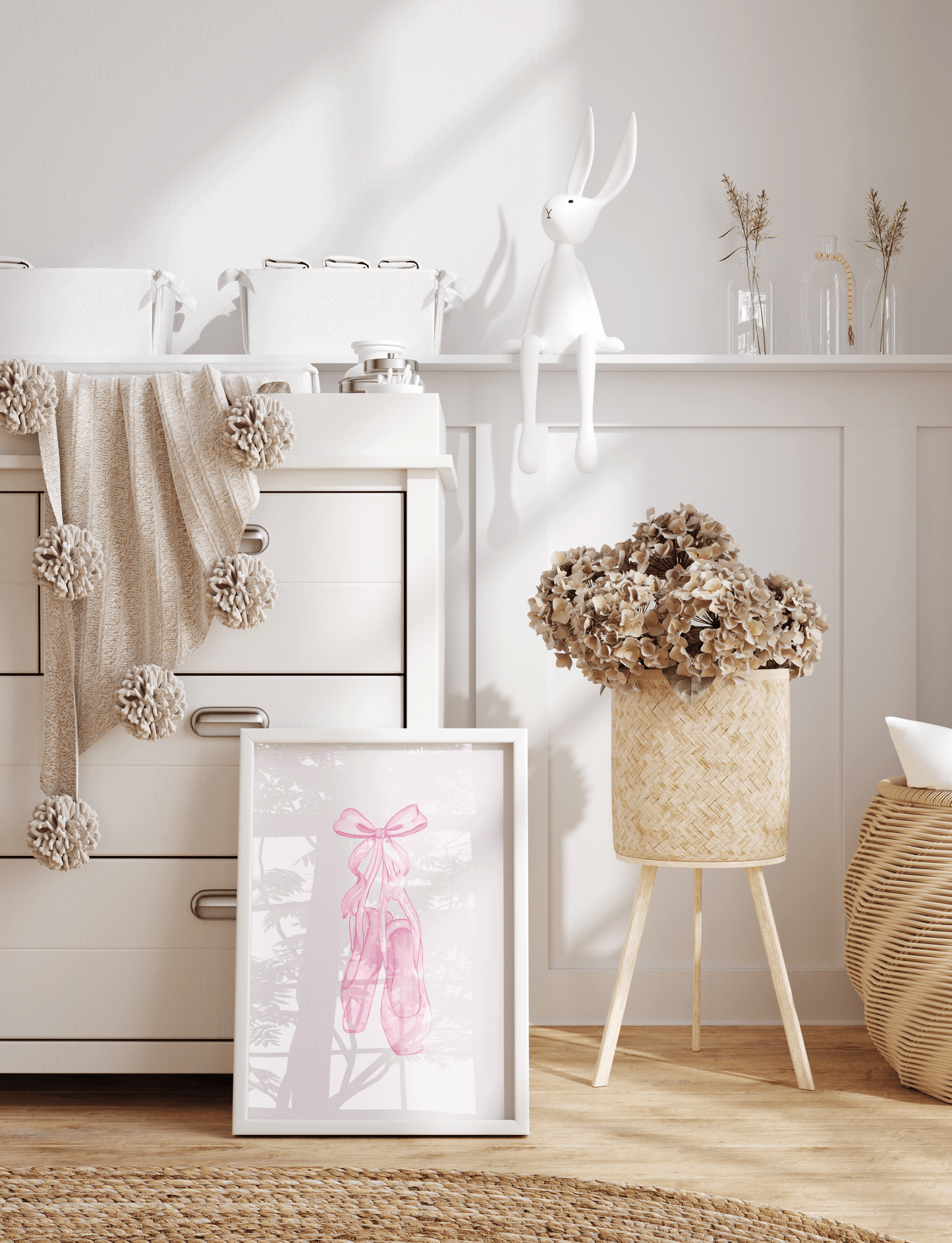 A framed art print featuring pink ballet slippers with pink coquette bow, in a nursery setting next to white dresser