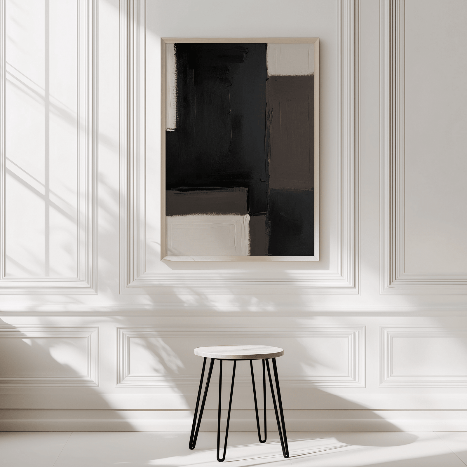 Bold black, beige and brown blocks in neutral tones with a light wood frame on a white wall with wainscotting detail.