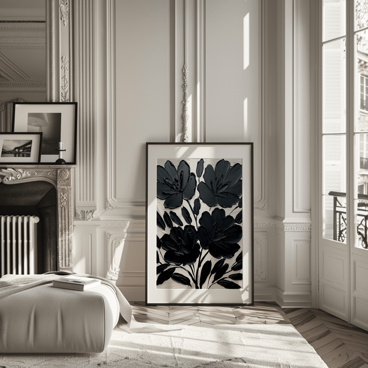 Large black floral wall art print leaning against wall in modern living room with natural light