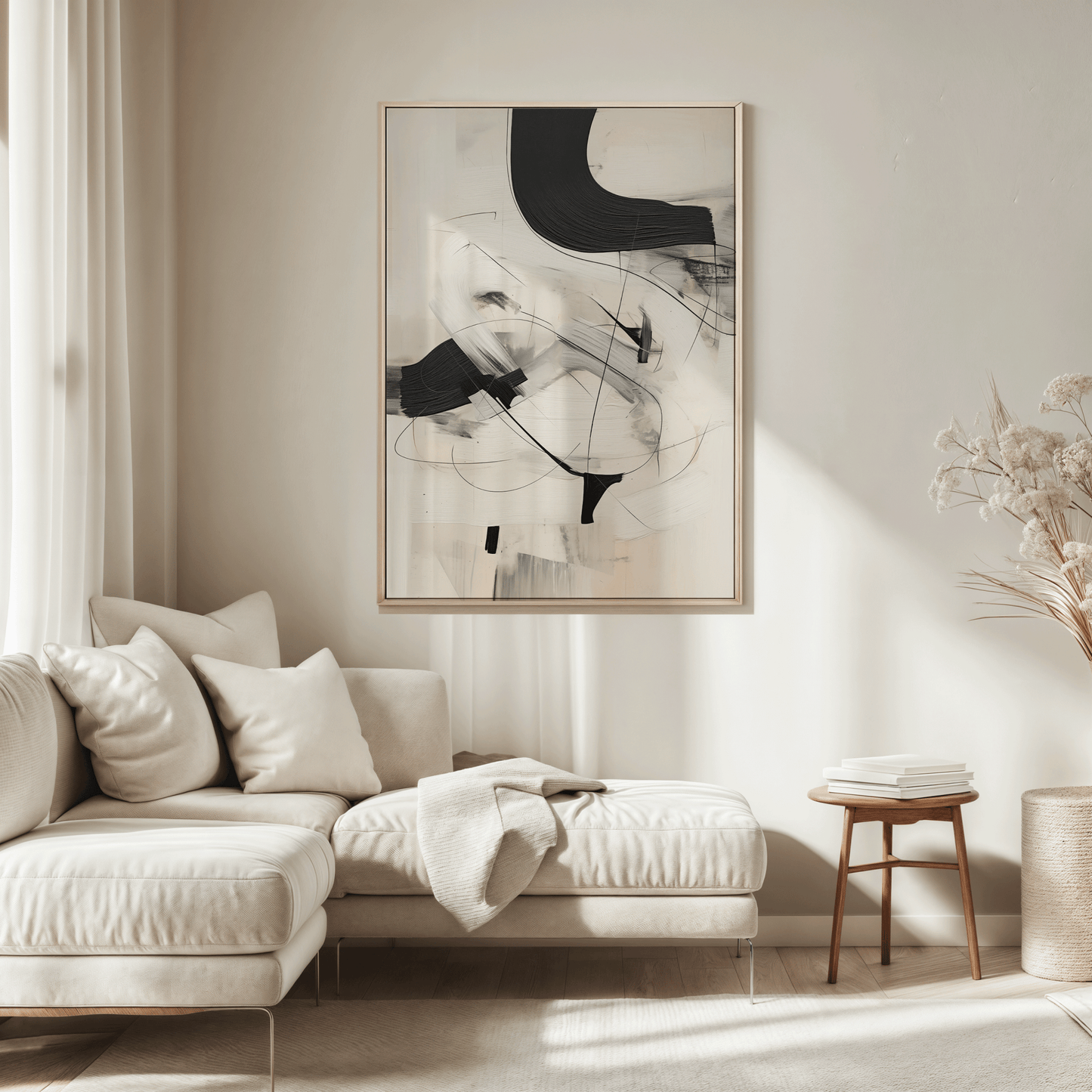 Framed black, beige, and white abstract artwork with faux brushstrokes over a sectional sofa on a warm beige wall in a living room.