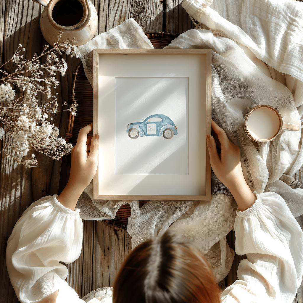 Child holding a framed blue watercolour car print on a cozy blanket