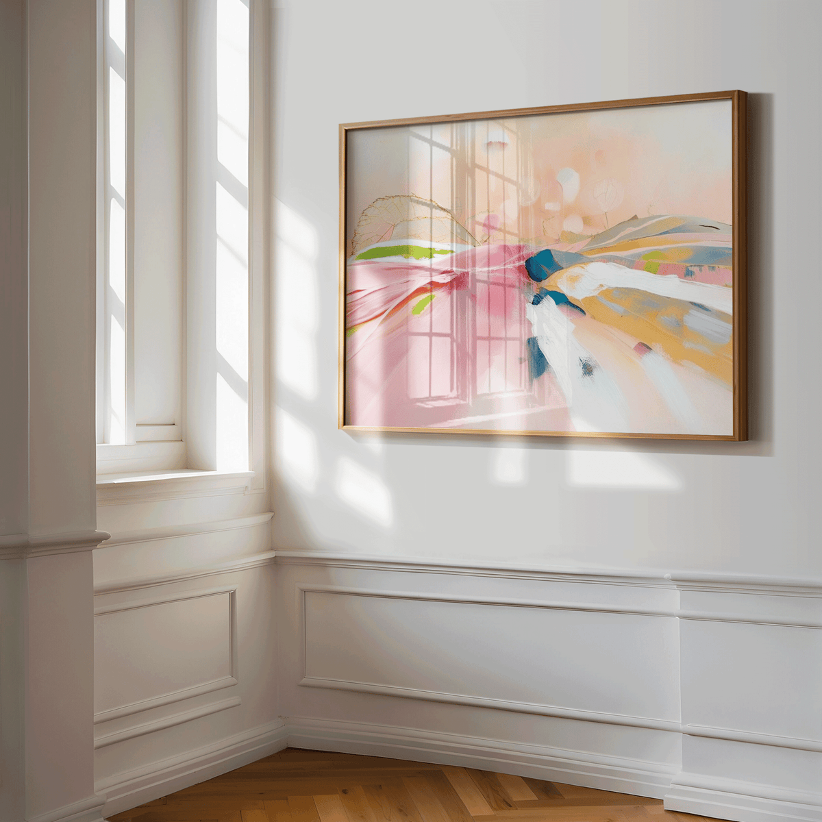 Blush pink abstract landscape wall art in a natural wood frame on a white panelled wall in soft window light