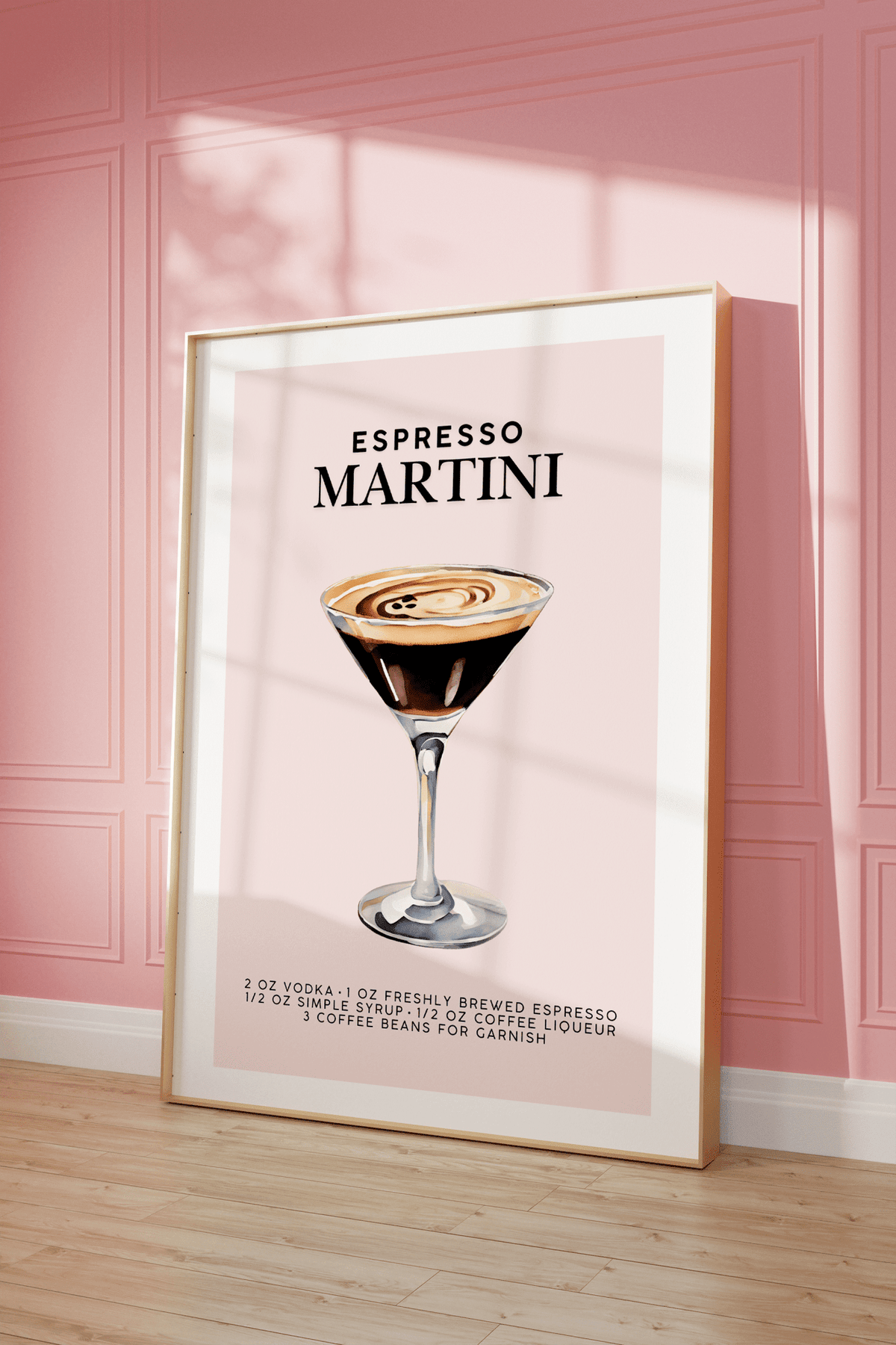 Blush pink espresso martini print in a natural frame leaning against a pink panelled wall