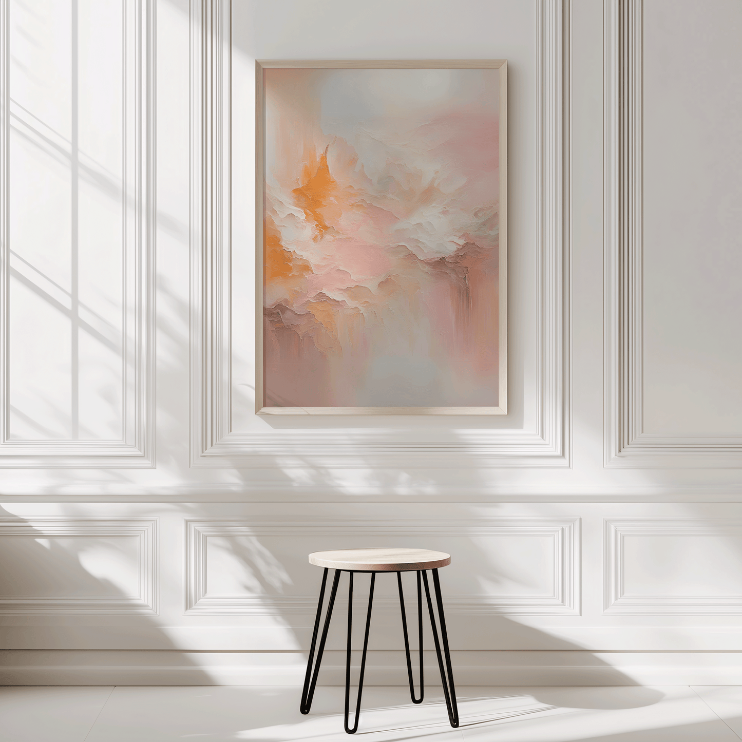 Peach and pink abstract wall art framed in light wood styled in bright white-panelled room