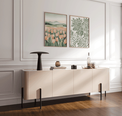 Set of two dining room wall art prints including a botanical leaf design and a soft tulip landscape, displayed side by side in light wood frames above a neutral console table