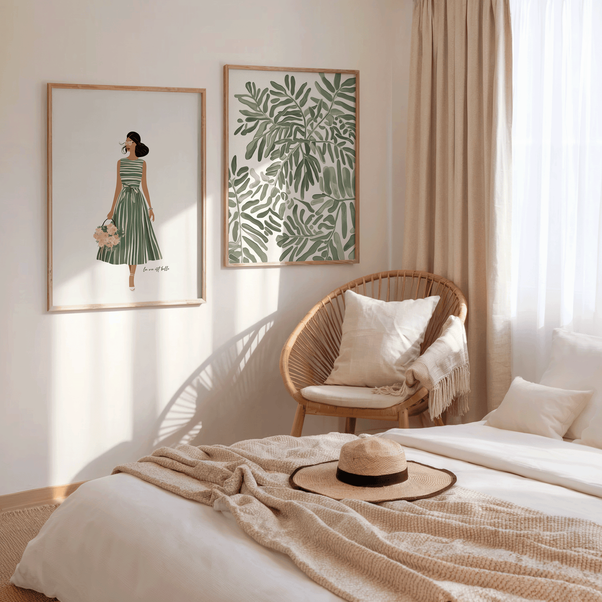 Set of two framed canvas wall art prints including a botanical leaf design and a woman in a green dress, displayed side by side in light wood frames in a neutral, boho bedroom