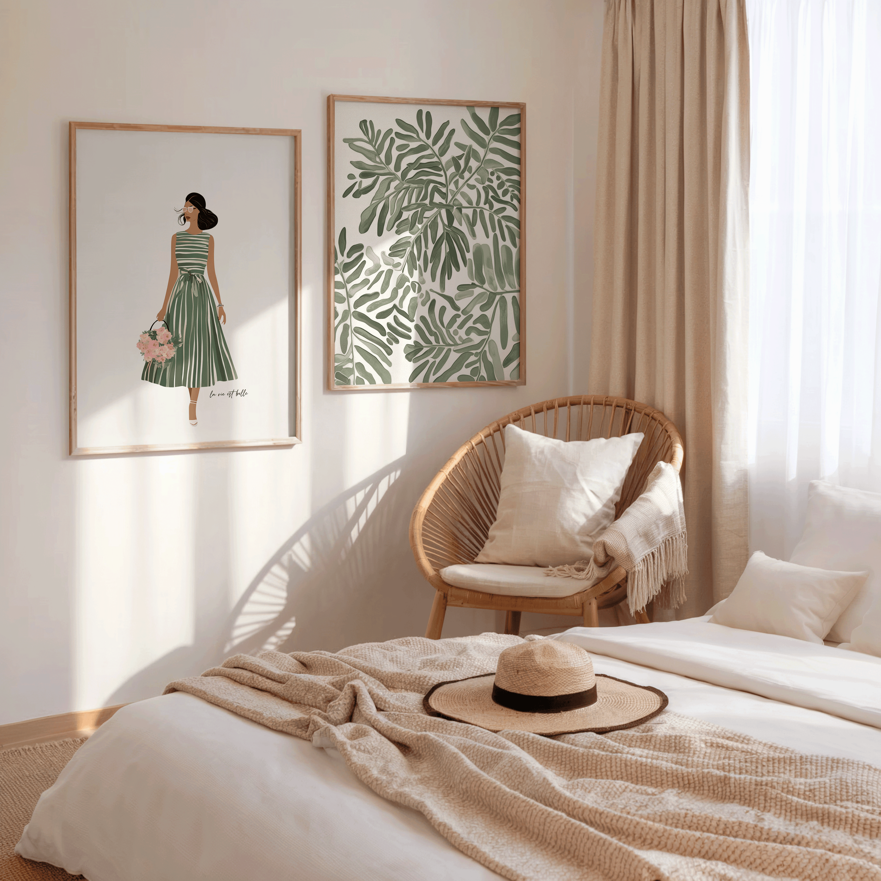 Set of two framed canvas wall art prints including a botanical leaf design and a woman in a green dress, displayed side by side in light wood frames in a neutral, boho bedroom