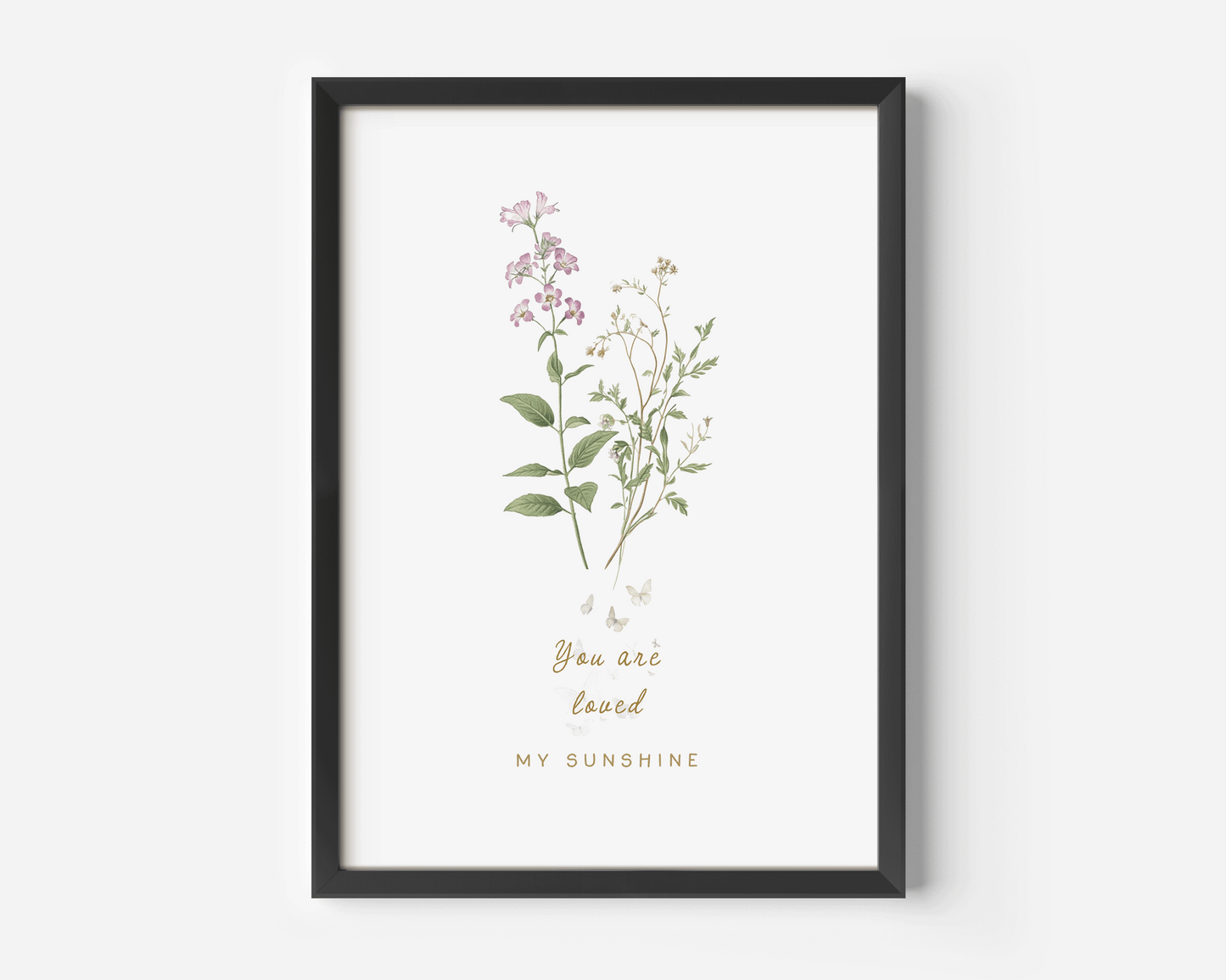 Botanical wildflower nursery wall art in a black frame featuring soft pink florals and delicate greenery, styled against a clean white background with a minimalist aesthetic.