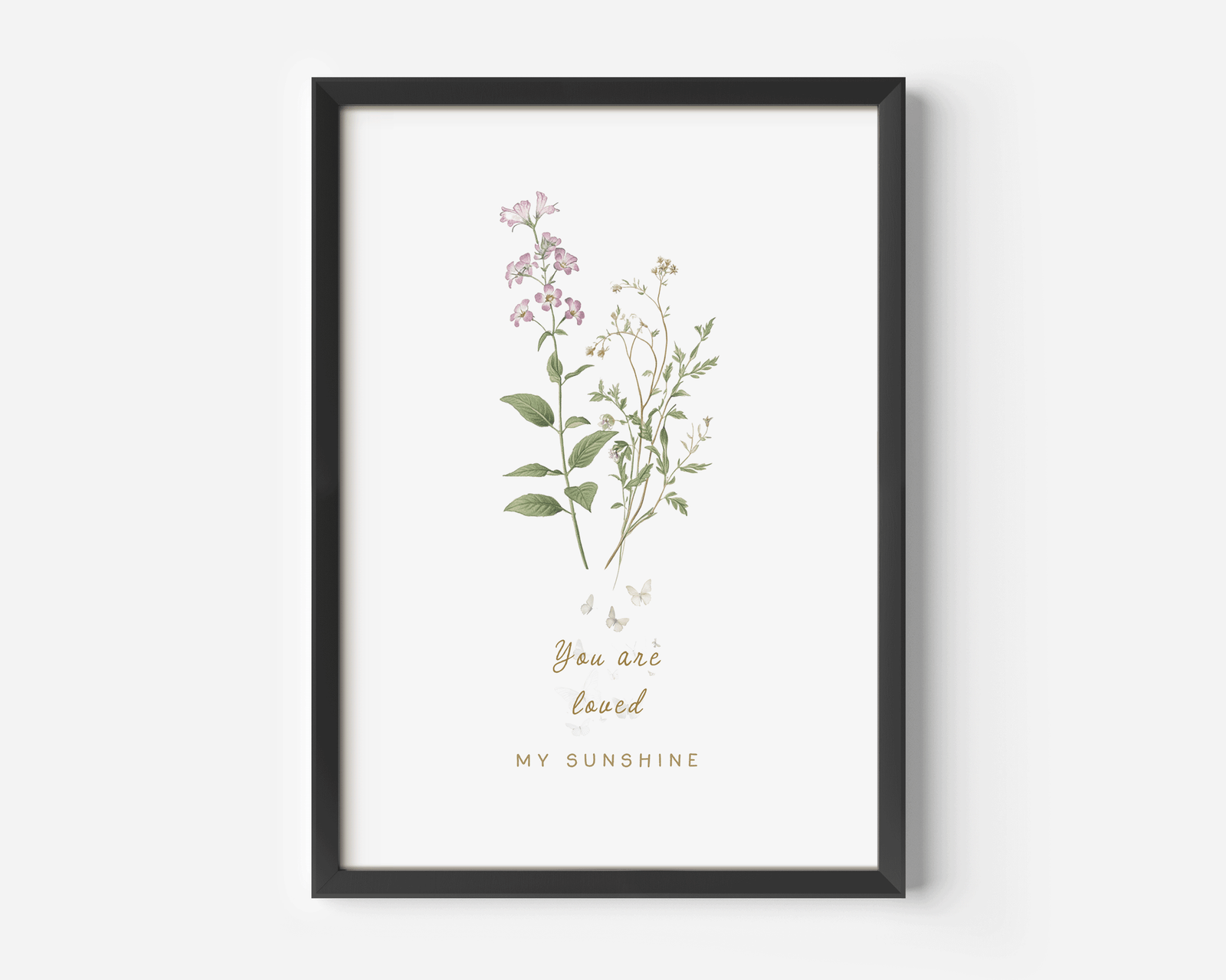 Botanical wildflower nursery wall art in a black frame featuring soft pink florals and delicate greenery, styled against a clean white background with a minimalist aesthetic.