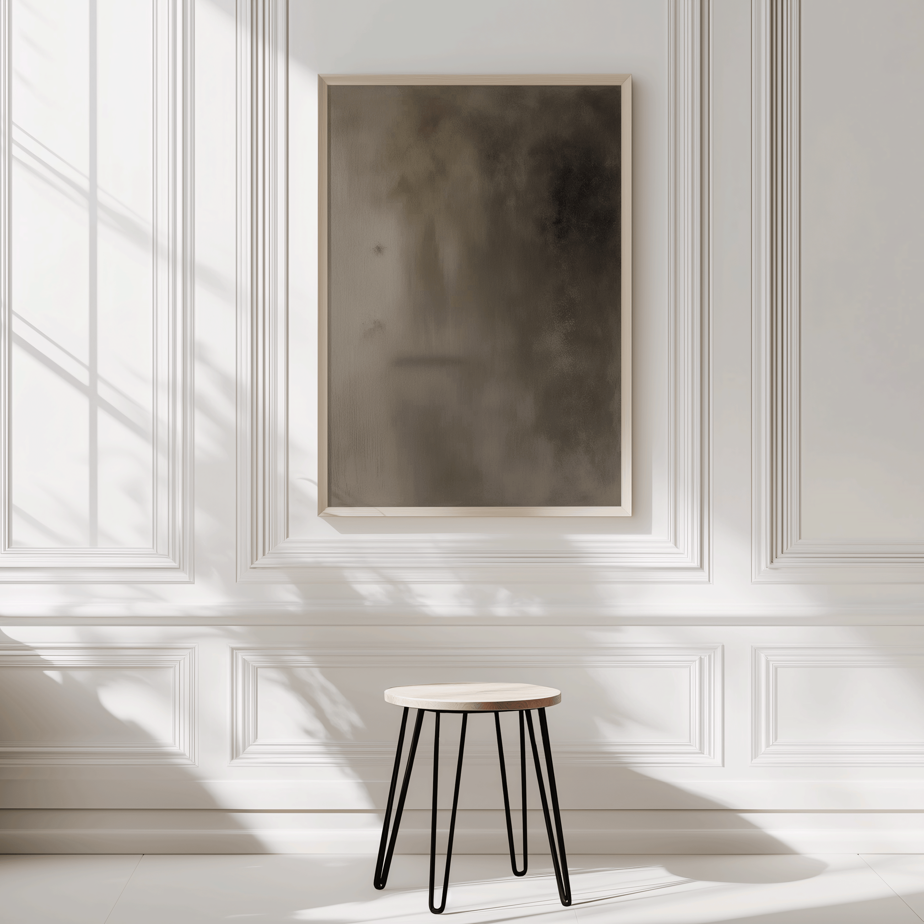 Earthy brown abstract wall art framed in light wood against white panelled wall with natural sunlight