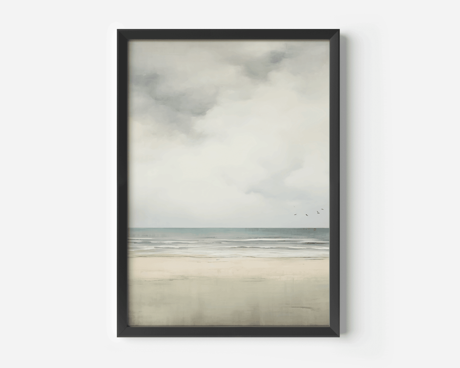 Framed neutral ocean and sky landscape wall art with a black frame on a white wall