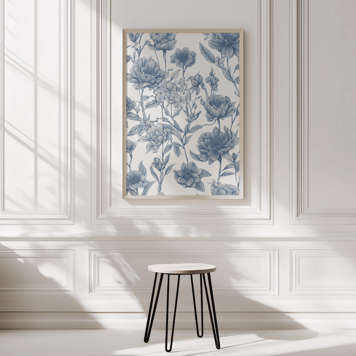 Chinoiserie print in a natural wood frame on a white panelled wall above a black stool