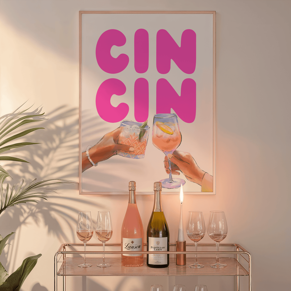 Cin cin wall art in a natural frame above a glass bar cart with wine bottles and a candle