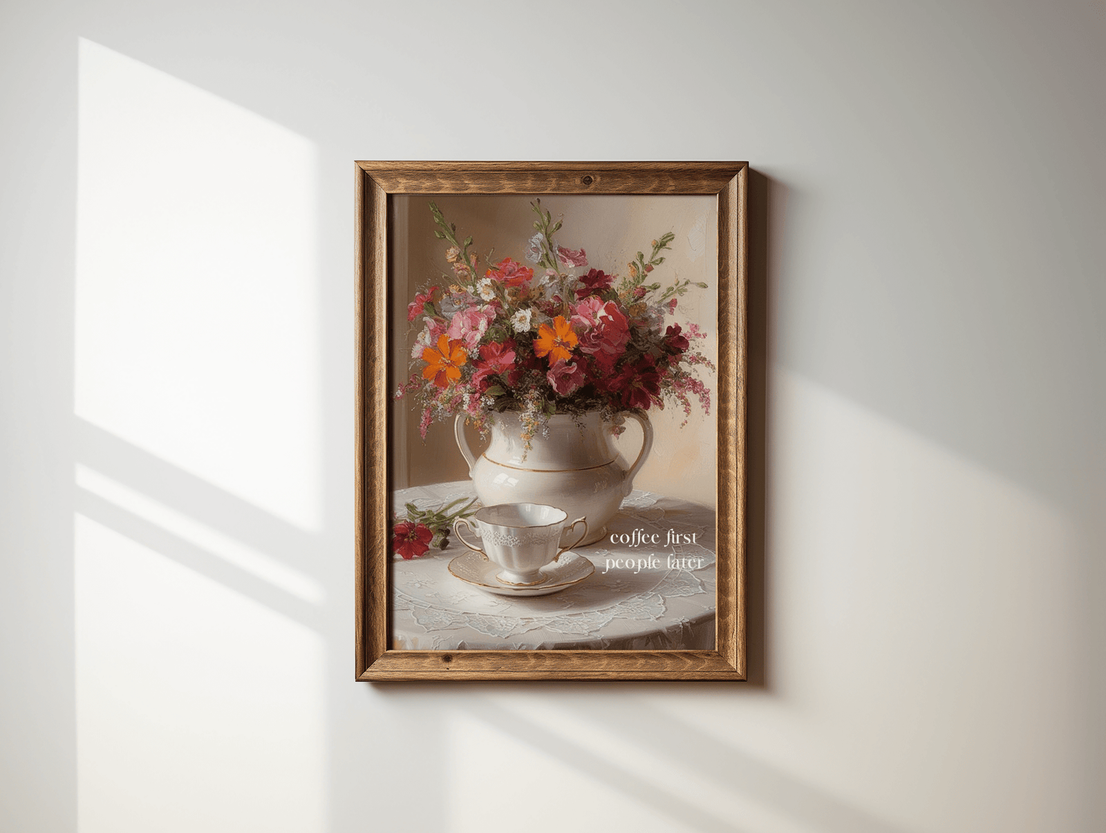 Coffee first, people later vintage floral print in an ornate gold wood frame on a sunlit white wall