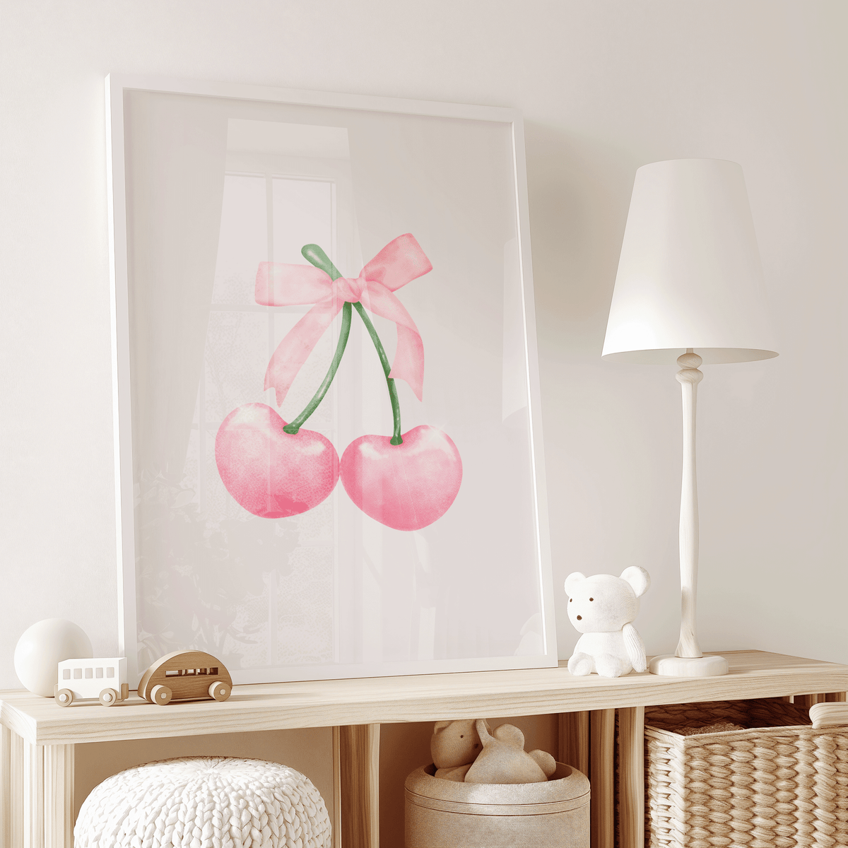 Coquette pink cherry framed wall art print leaning against boho nursery dresser