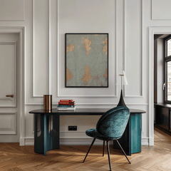Cracked blue and gold print above a dark desk with a teal velvet chair