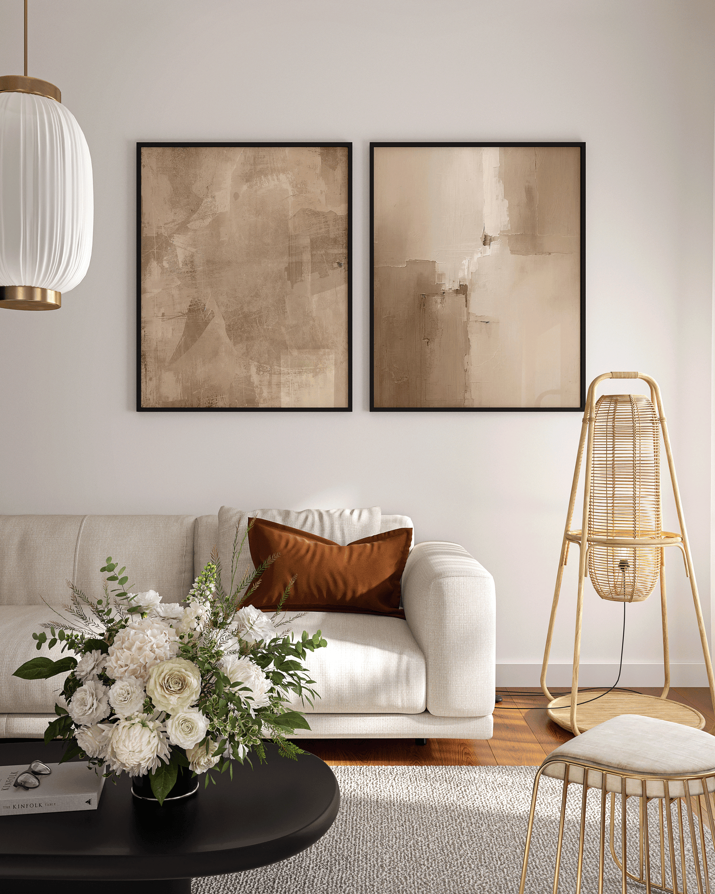 pair of beige and brown abstract prints framed in sleek black frames above a modern cream sofa with gold accents and warm minimalist décor