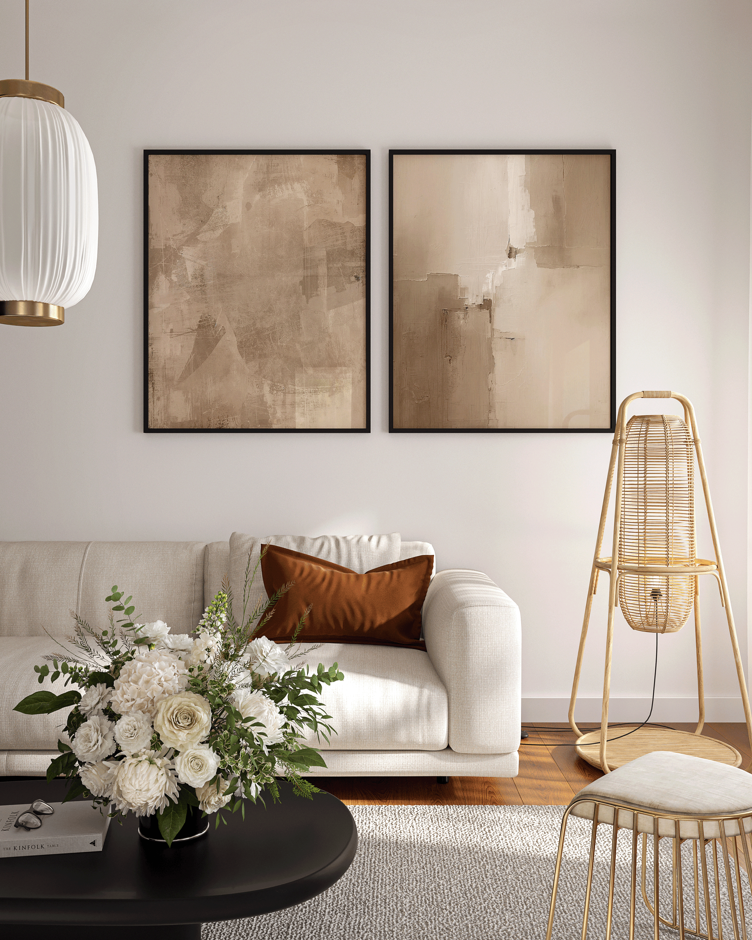 pair of beige and brown abstract prints framed in sleek black frames above a modern cream sofa with gold accents and warm minimalist décor