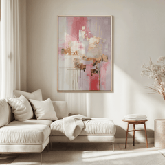 A creamy white, blush pink, and gold metallic accents framed abstract wall art above a cream sofa sectional in a neutral, modern living room.