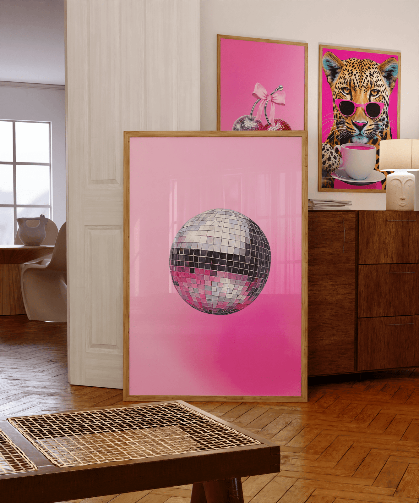 Disco ball wall art in a funky gallery wall with pink and leopard prints on a wooden sideboard