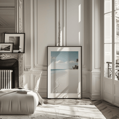large framed beach print leaning against wall in elegant, modern living room with molding and soft light, serene ocean view