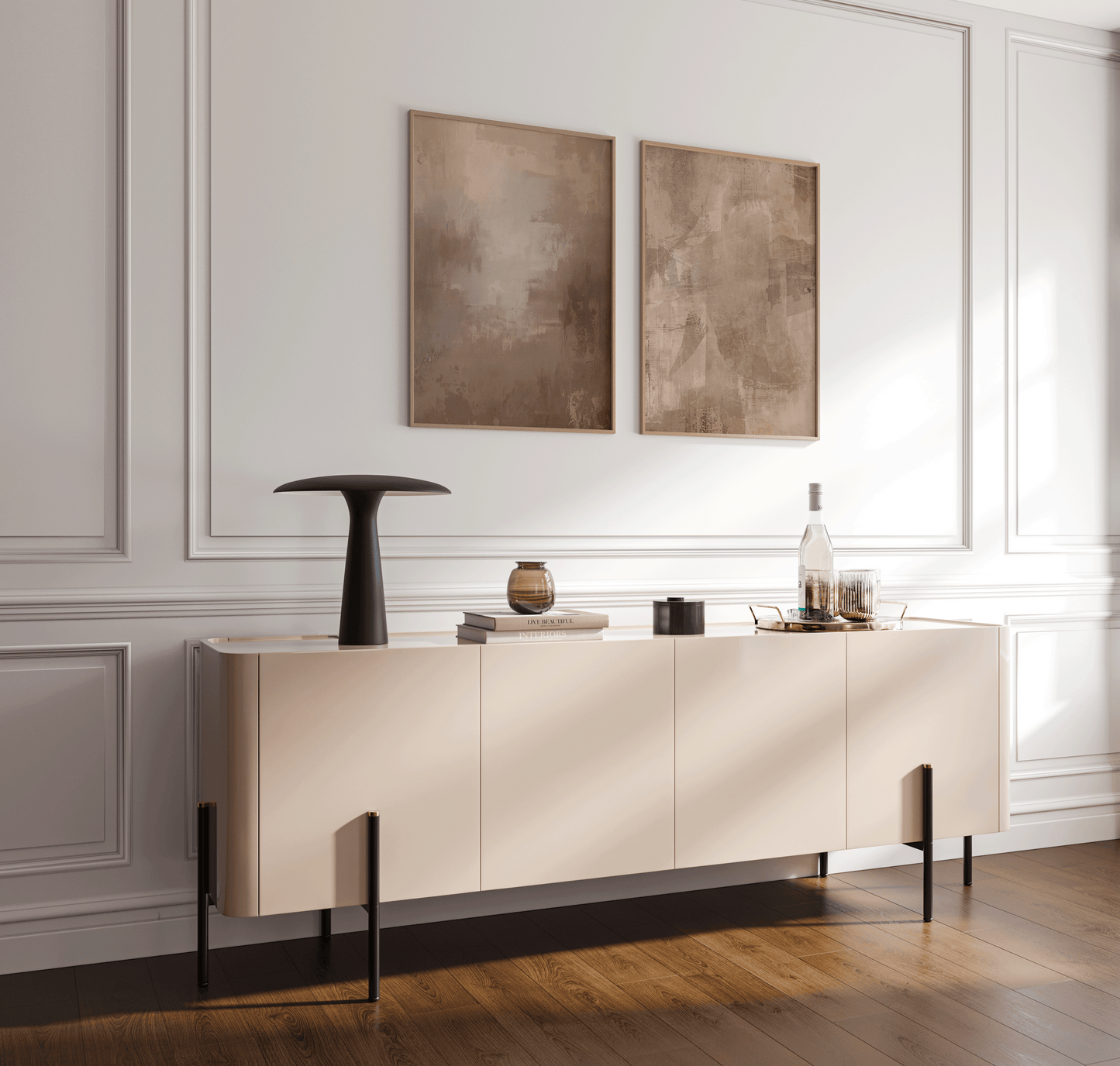 pair of earthy beige and brown abstract prints in wood frames styled above a minimalist console table in a bright entryway with paneled walls