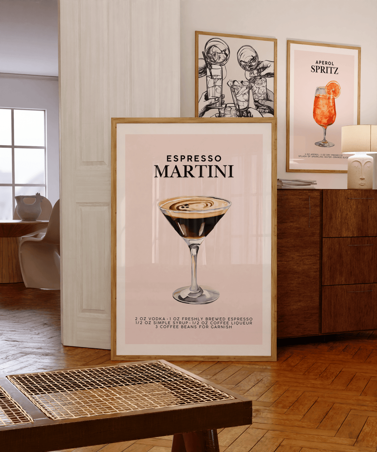 Espresso martini art in a bar cart gallery wall beside an Aperol spritz print on a wooden sideboard