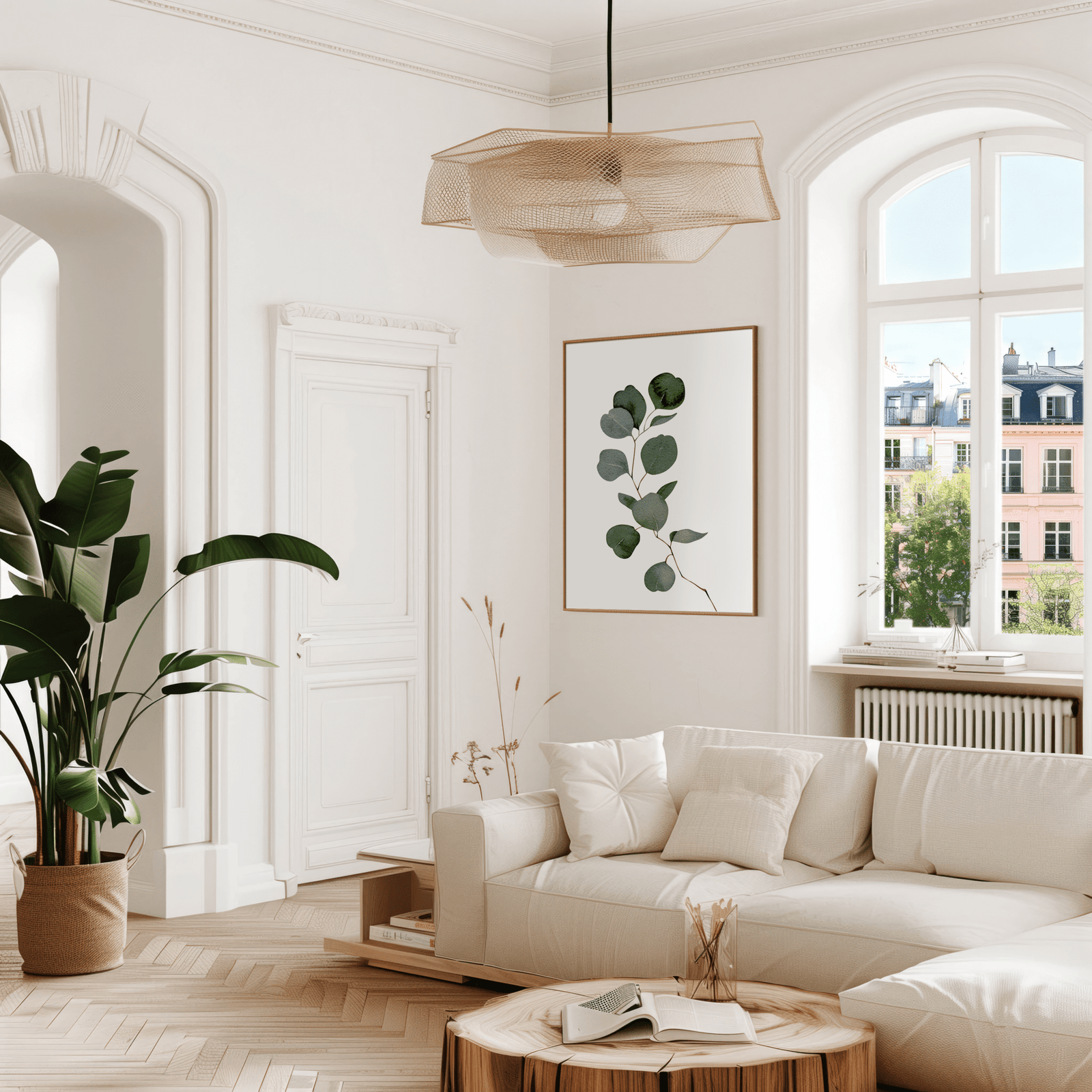 Watercolour eucalyptus print in a gold frame above a cream sofa in a bright living room