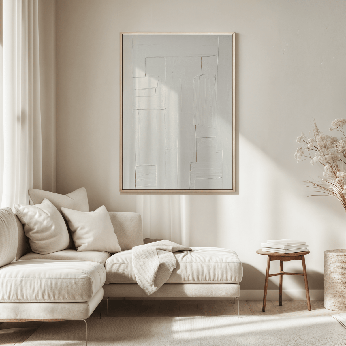 Modern neutral living room with a beige sofa and white on white abstract art in a frame