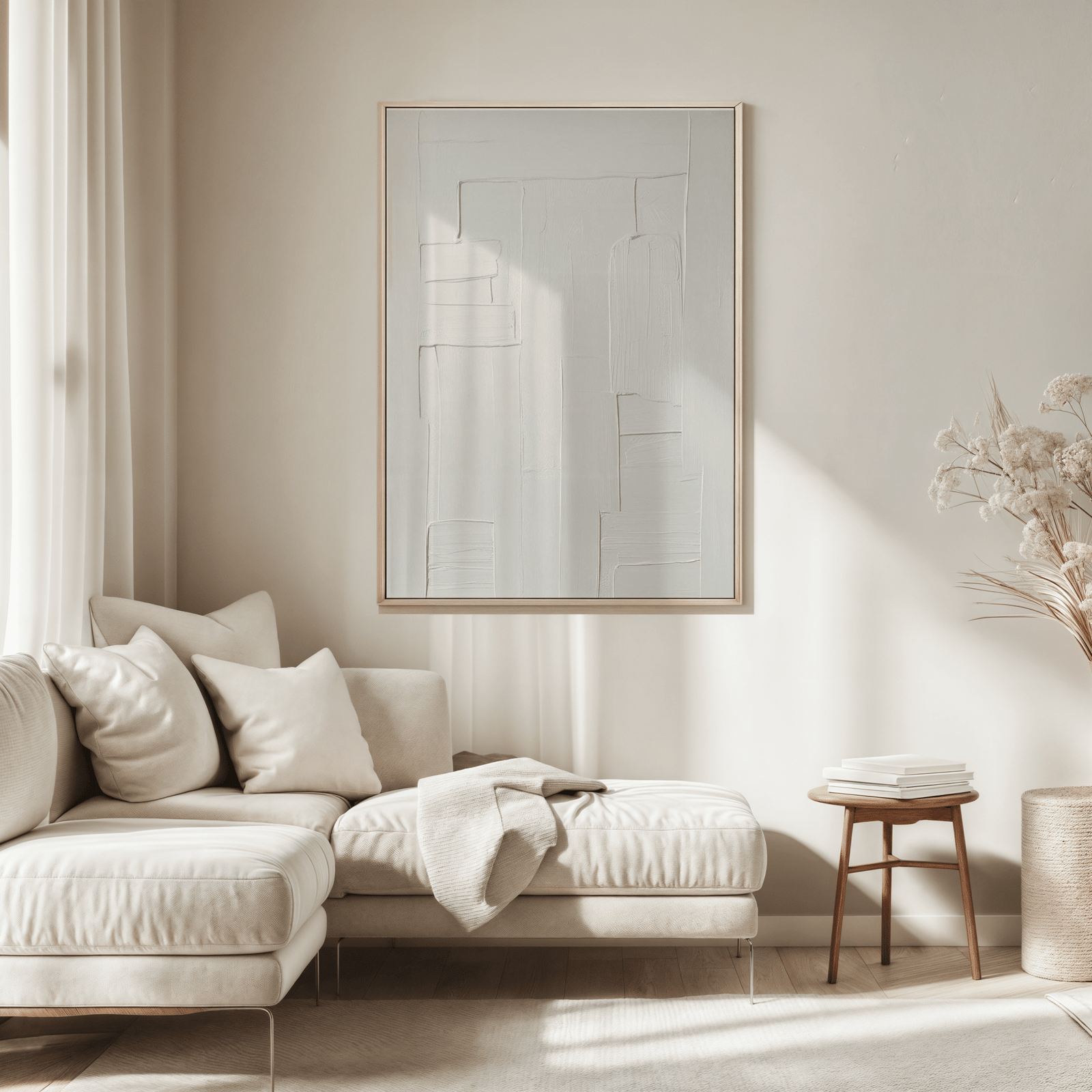 Modern living room with a neutral color scheme, featuring a beige sofa, all white faux-textured framed abstract art, and minimal decor.