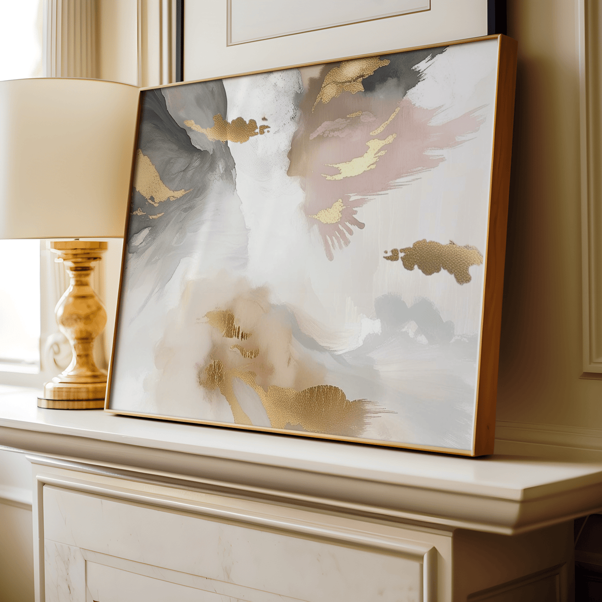 Framed modern abstract artwork with blush pink, gold foil accents, light and dark grey, white and beige colors on a fireplace in a living room.