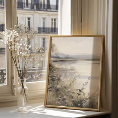 Beige neutral framed landscape wall art styled near window with natural sunlight